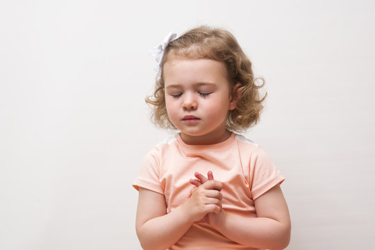 Portrait of little cute girl who prays or dreams