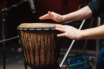 African drum, microphone studio recording, drummer beats the drum with his hands movement