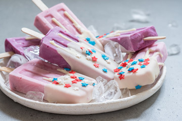 Yogurt popsicles topped with white chocolate and american stars sprinkles