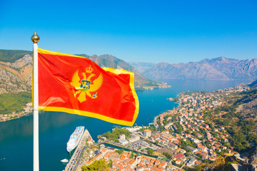National flag of Montenegro waves in Boka Kotorska bay, Montenegro