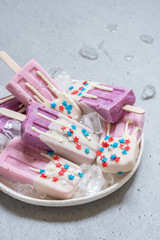 Yogurt popsicles topped with white chocolate and american stars sprinkles