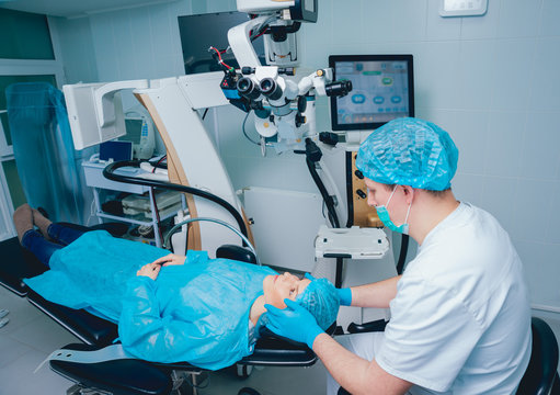 Eye surgery. A patient and surgeon in the operating room during ophthalmic surgery. Vision correction