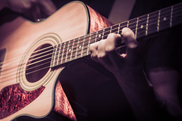 Obraz na płótnie Canvas Man playing acoustic guitar on dark background. A musical concept.
