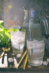 Refreshing healthy summer drink with rhubarb. Pieplant lemonade in glass on wooden background. Homemade rhabarbarum compote.