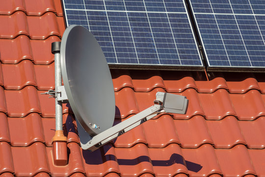 Solar Energieanlage oder Photovoltaikanlage auf einem Dach mit Satelittenempfangsanlage