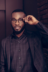 Obraz premium Handsome intelligent man fixing his glasses