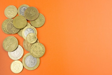 Worlds coins on orange texture.  Money concept. Empty space
