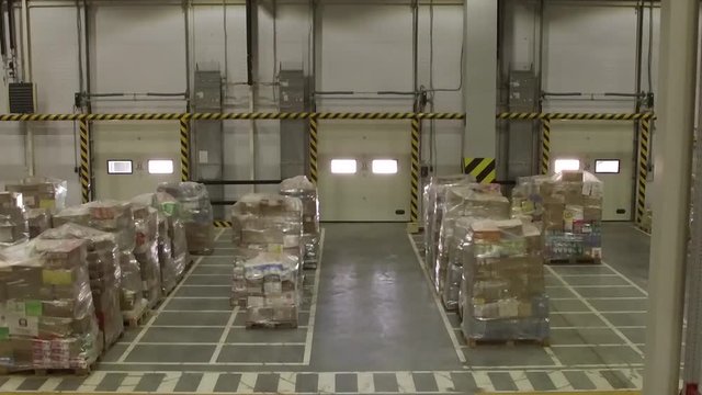 Shelves and racks in distribution warehouse interior.Rows with cardboard boxes and goods at shelves.Logistic, transportation and storage concept.