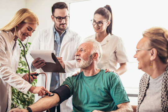 Image Of Young Medic Taking Blood Pressure During Home Visit