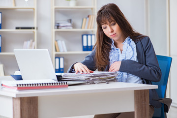 Pregnant woman struggling to do work in office