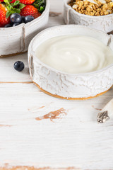 Bowl of natural yogurt with granola and fresh berries