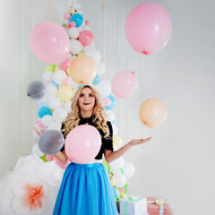 Beautiful young blonde with balloons. Colorful balls.