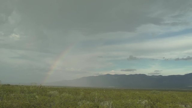 RainBow In Potosi Desert With Rain Clouds and Mountain in Background