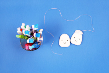 Toothbrushes and dental floss on blue background