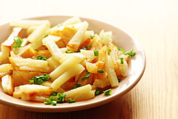 Potato in a plate on a wood background