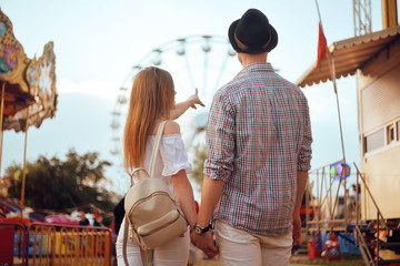 Beautiful, young couple having fun at an amusement park. Couple Dating Relaxation Love Theme Park...