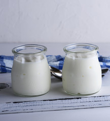 homemade yogurt in a glass jar on a white wooden board