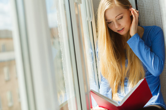 Woman reading on windowsill