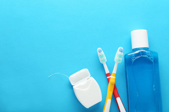 Toothbrush with mouthwash bottle on blue background