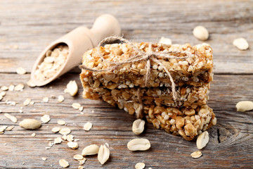 Tasty granola bars with nuts on wooden table