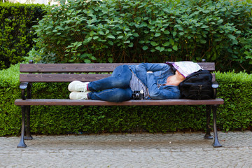 The girl is sleeping on a bench