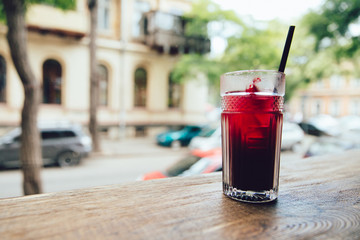 Clode-up view of wineglass wit fruit cocktail on the table, at cafe, outdoors.