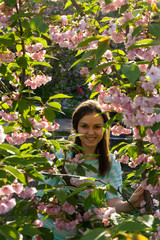 smiling girl looking from behind branches