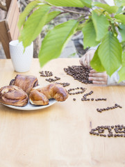 scattered coffee on the table, the child writes coffee beans letters on a wooden background