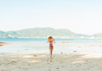 Fototapeta premium Portrait of back of model sitting at seaside outdoors