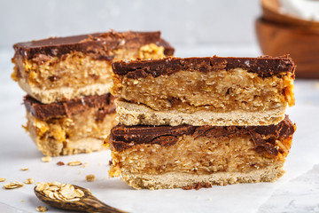 Coconut-oat raw vegan cake with chocolate. Top view, light background, copy space. Healthy vegan food concept.