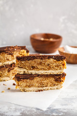 raw vegan cake, raw vegan, vegan dessert, vegan food, Coconut-oat raw vegan bars with chocolate. Top view, light background, copy space. Healthy vegan food concept.