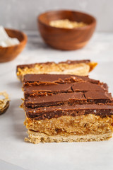 Coconut-oat raw vegan sliced cake with chocolate. Top view, light background, copy space. Healthy vegan food concept.