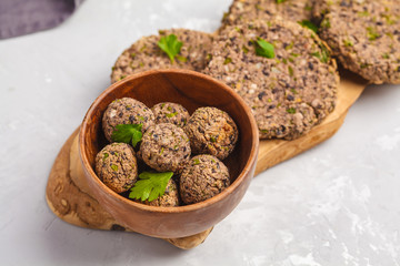 Vegan beans burgers (cutlets) and meatballs with parsley on a wooden board, top view copy space. Healthy vegan food concept.