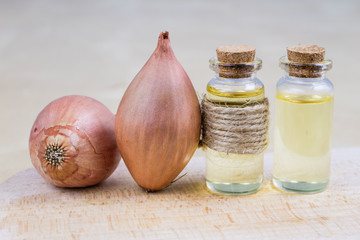 Syrup of onion in a small vial on a wooden table. Flu medicine in a small glass container.