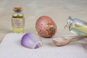 Syrup of onion in a small vial on a wooden table. Flu medicine in a small glass container.