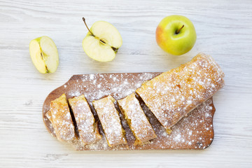 Strudel or apple pie on wooden board. Top view. Closeup.