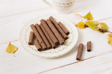 chocolate rolls and coffee,yellow leaves.wooden background.close-up view