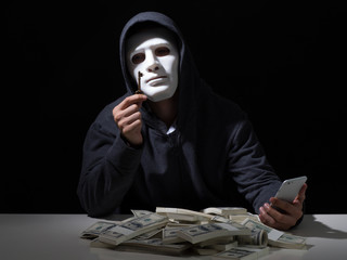 Cyber attack with unrecognizable hooded hacker.Hacker steal money in the office.