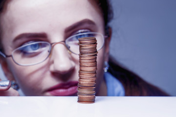 Business woman with column coins as symbol of investment or growth. (Money, wealth,...