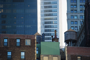 Close-up view of the New York skyscrapers with water tanks on the roof of some buildings. Fall season in Manhatthan, Usa.