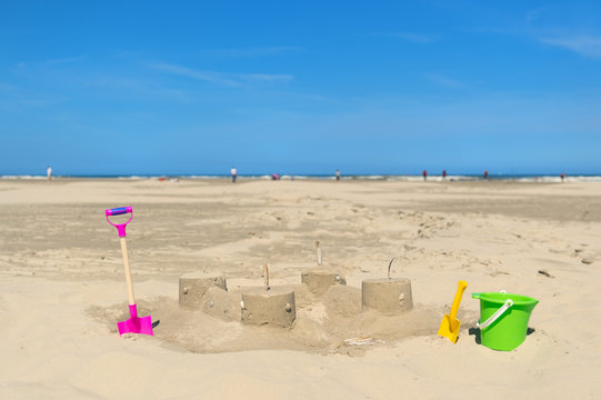 Sand castle with toys at the beach
