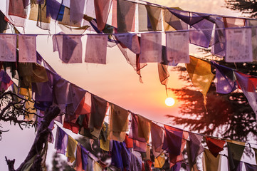 'Selective focus' Vew of some colorful Tibetan flags illuminated by a beautiful sunset in the summit of a Himalayan mountain.