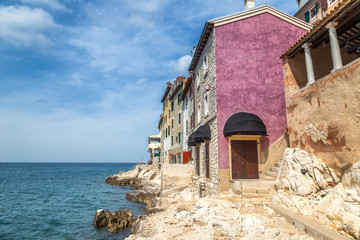 Fototapeta na wymiar Historic buildings on the coast of Rovinj town on Adriatic sea, one of major tourist attractions at Istria in Croatia, Europe.
