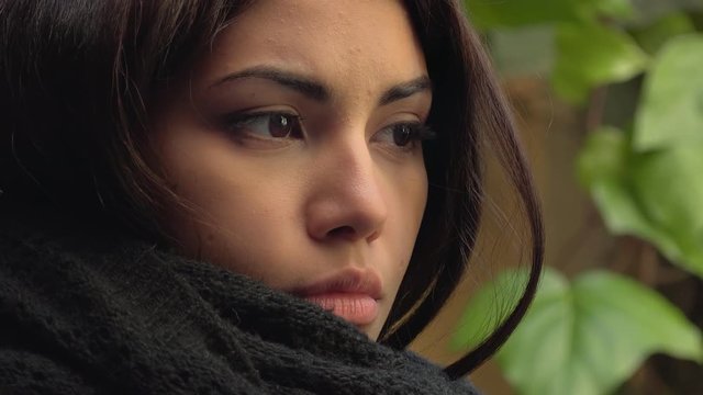 sad and pensive asian woman's look, wearing black scarf- outdoor