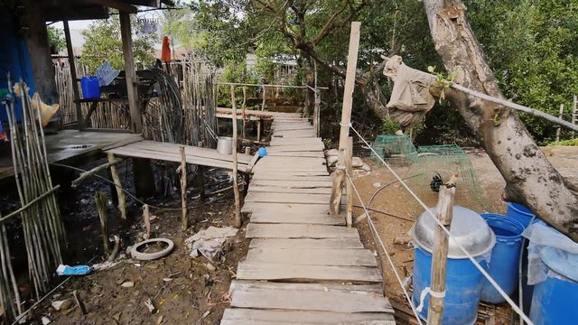 Houses of the poor in the Filipino slums. The swamp. Wooden bridges from planks on high water. Clothes on laces. Shooting in motion.