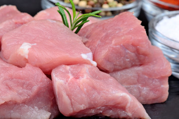 Pieces of pork with spices on slate