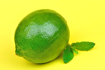 Fresh lime with mint on yellow background