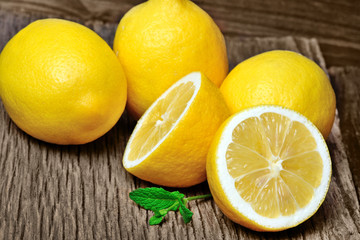 Fototapeta na wymiar Heap of fresh lemons with mint on old table