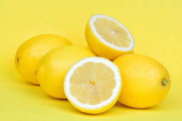 Obraz na płótnie Canvas Heap of lemons on yellow background