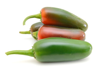 Close up image of bunch of green jalapeno peppers against white background